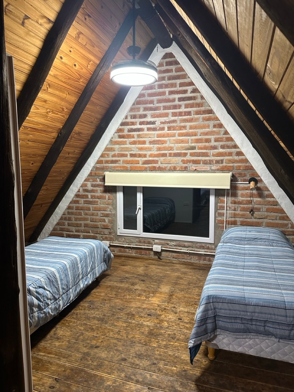 Dormitorio con camas individuales dentro de una cabaña